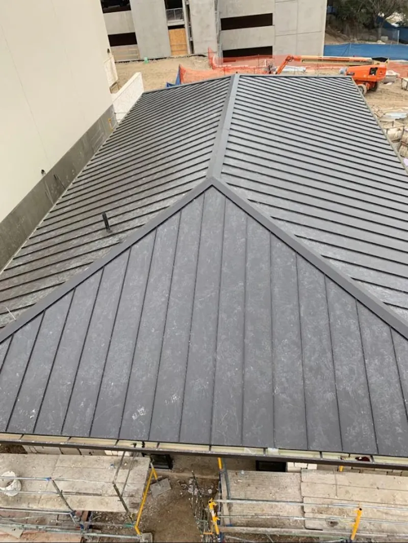 Commercial metal roof construction with crane equipment in Hastings